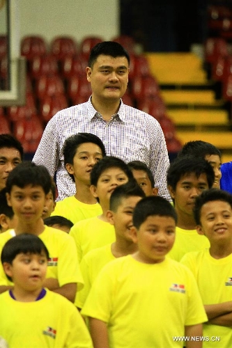 Former Chinese basketball superstar Yao Ming (Back) poses with children for photos during a basketball clinic in Pasig City, the Philippines, May 5, 2013. Yao and his Shanghai Sharks are in Manila on a friendly visit. They will attend two exhibition games respectively with the Smart Gilas Team and the Philippine Basketball Association (PBA) Selection. (Xinhua/Rouelle Umali) 