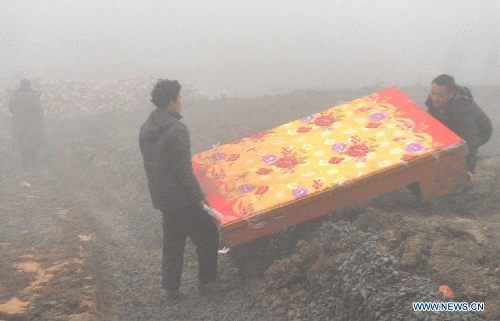 Villagers carry a mattress donated by a company in the makeshift tent area near the Gaopo Village in Zhenxiong County of Zhaotong City, southwest China's Yunnan Province, Jan. 14, 2013. Forty-six people died and 2 others injured in a landslide which hit the Zhaojiagou area of Gaopo Village around 8:20 a.m. on Jan. 11. More than 500 villagers have been moved to makeshift tents near the village. (Xinhua/Chen Haining)