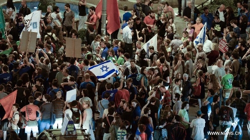 Hundreds of Israeli protesters gathered in front of the residence of Prime Minister Benjamin Netanyahu in Jerusalem on May 18, 2013, carrying signs that read 
