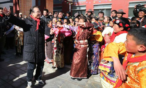 Chinese Premier Wen Jiabao (L front) dances with pupils as he visits the Hongqi Elementary School which has been rebuilt after a devastating earthquake in 2010, in Yushu Tibetan Autonomous Prefecture in northwest China's Qinghai Province, December 31, 2012. Wen paid a visit in quake-hit Yushu before New Year's Day to inspect the reconstruction work and extend New Year's greetings to the people there. Photo: Xinhua