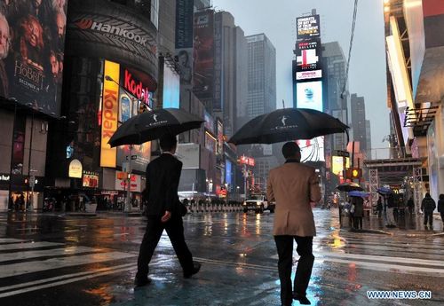 Tourists walk at the Times Square in New York, the United States, on October 29, 2012. Hurricane Sandy, a massive storm described by forecasters as one of the largest ever that hit the United States, is making its way towards the population-dense East Coast. Michael Bloomberg, mayor of New York, has asked the public to stay at home when Sandy slams the city. Nearly 10,000 flights have been canceled for Monday and Tuesday by airlines bracing for Hurricane Sandy. Photo: Xinhua