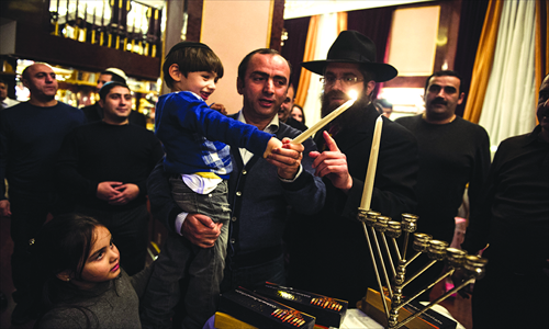 2. Lighting the first candle of Hanukkah.
