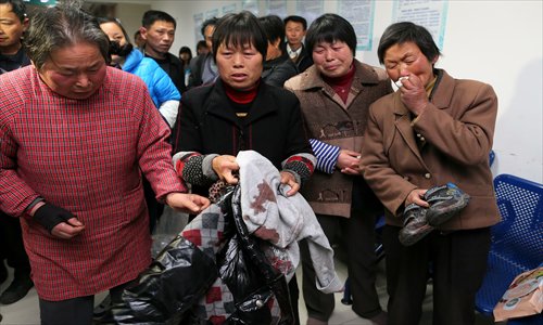 Relatives hold the blood-stained jacket of a student at the Fengxian Central Hospital in Shanghai Wednesday, hours after a man surnamed Zang murdered two women and injured 11 people at the Jinhui Primary School. Photo: Yang Hui/GT