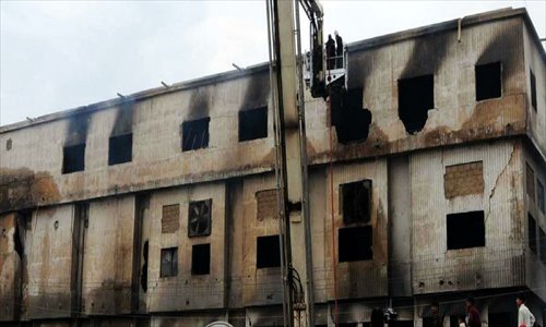 Pakistani firefighters conduct rescue operation at the garments factory in southern Pakistani port city of Karachi, Sept 12, 2012. A huge fire that broke out in a garments factory in Pakistan's southern port city of Karachi on Tuesday evening has been put out after nearly 11 hours of hard efforts by fire fighters, announced Ehtishamuddin, Chief Fire Officer of Karachi, on Wednesday. Up till now, a total of 166 people have reportedly been killed in the fire. Photo: Xinhua