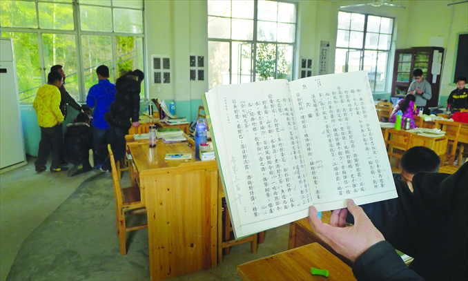 Students take a break at Wangcaigui Classical School in Zhejiang Province, as a teacher studies a classical text. Photo: Liu Dong/GT