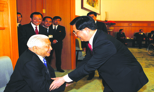Chinese President Hu Jintao (right) shakes hands with Christian leader Ding Guangxun at the 4th session of the 10th Chinese People's Political Consultative Conference in Beijing on March 3, 2006. Photo: Xinhua 