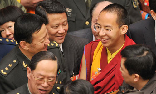 The 11th Panchen Lama Bainqen Erdini Qoigyijabu, also a member of the 11th National Committee of the Chinese People's Political Consultative Conference (CPPCC), talks to other members after the closing meeting of the Fifth Session of the 11th CPPCC National Committee in Beijing, March 13, 2012. Photo: Xinhua