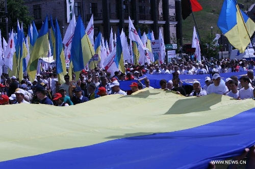 Demonstrators hold a giant Ukrainian flag during an opposition rally in central Kiev, capital of Ukraine, on May 18, 2013, demanding to release jailed former Ukrainian prime minister and leader of the opposition Yulia Tymoshenko. (Xinhua/Muliming) 