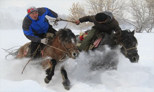 Two men race horses in Lasite township, Altay, Xinjiang Uyghur Autonomous Region on Friday. Horse races are an age-old traditional pastime in the area. Photo: CFP