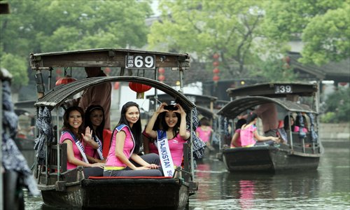 Contestants in the Asia final for this year's Miss Tourism Queen International competition enjoy a boat ride on Friday in Xitang, Zhejiang Province. Xitang, a renowned historical town, has hosted the competition for five consecutive years. Some 40 contestants from 40 countries and regions are competing in the final. Photo: IC