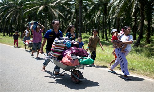 Residents of Tanjung Labian leave the village near where Filipino gunmen were locked down Sunday in a standoff in the surrounding villages of Tanduo in Sabah. Malaysian police said they had arrested 79 people on Borneo island as skirmishes to end an incursion by Islamists left one more dead. Photo: AFP