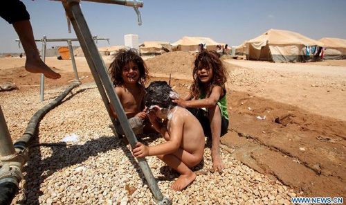 Syrian refugee children are seen at the Zaatari camp for Syrian refugees, 15 kilometres (nine miles) from the kingdom's northern city of Mafraq, near the border with Syria, on August 11, 2012. There are now about 3,000 Syrians taking shelters in the desert Zaatari refugee camp that was opened last month to alleviate the humanitarian crisis. Photo: Xinhua