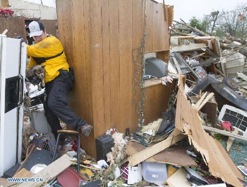 A rescuer brings out a dog from a damaged house in Shawnee, Oklahoma, the United States, May 20, 2013. Two men were confirmed dead after tornadoes hit the U.S. state of Oklahoma, officials said Monday. (Xinhua/Marcus DiPaola) &nbsp;