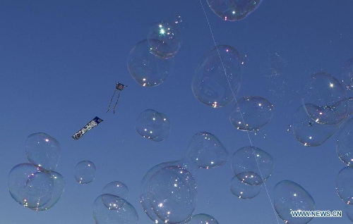 Kites fly over soap bubbles during the 24th Annual Four Winds Kite Festival at the Kortright Centre for Conservation in Toronto, Canada, May 4, 2013. (Xinhua/Zou Zheng)