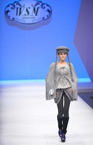 A model presents a creation in the WSM China Knitwear Fashion Design Contest 2013 during the China Fashion Week in Beijing, capital of China, March 26, 2013. The design by Sheng Lina from Fashion School & Engineering of Zhejiang Sci-Tech University won the championship of the contest. (Xinhua/Li Xin)