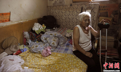 A woman surnamed Tong, who lives diagonally opposite from Xu, explained she walks through the long and narrow alleys with difficulty ever since she broke her left leg years ago. Photo: Jin Shuo/chinanews.com 