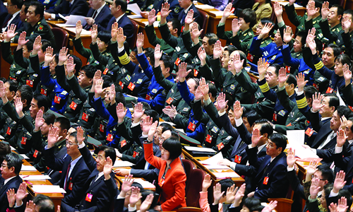 Delegates raise their hands to show approval for a work report at the closing ceremony of the 18th Party congress held at the Great Hall of the People Wednesday. Photo: IC