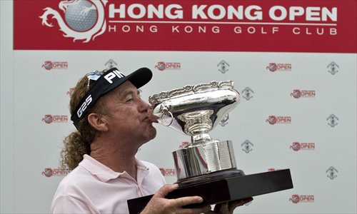 Miguel Angel Jimenez kisses the trophy after winning the Hong Kong Open on Sunday. Photo: AFP