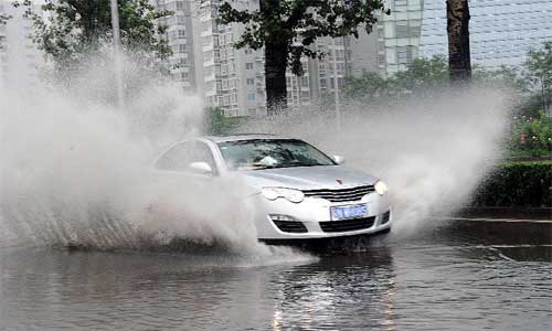 A vehicle drives in heavy rain in Beijing, capital of China, July 21, 2012. Photo: Xinhua