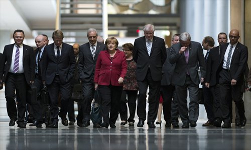 German Chancellor Angela Merkel (center) and her Christian Democratic party colleagues of the CDU/CSU make their way to the third round of  talks with the SPD party on forming a coalition government in Berlin on Thursday. Her search for a partner turned into a one-horse race, forcing her to haggle with the Social Democrats. Photo: AFP