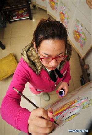 An apprentice of Huo Qingyou, a woodcut new year picture artist, adds colour to ink rubbings in Yangliuqing town, north China's Tianjin Municipality, Dec. 28, 2012. In Yangliuqing, dubbed 