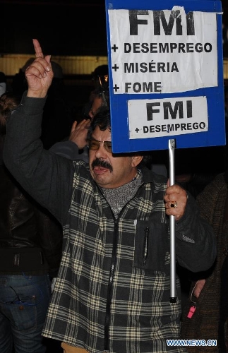 A protestor shouts slogans in front of the Internatioanl Monetary Fund (IMF) Office in Lisbon, Portugal, on Jan, 30, 2013. Hundreds of Portuguese gathered in front of the Internatioanl Monetary Fund (IMF) Office in capital Lisbon, protesting against IMF's demand of more spending cuts by the Portuguese government and its drastic austerity policy. (Xinhua/Zhang Liyun)