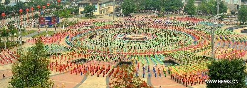 &nbsp; People gather on a square performing a traditional umbrella dance to celebrate the Water Splashing Festival, also the New Year of the Dai ethnic group, in Jinghong City, Dai Autonomous Prefecture of Xishuangbanna, southwest China's Yunnan Province, April 14, 2013. (Xinhua/Qin Qing)&nbsp; 