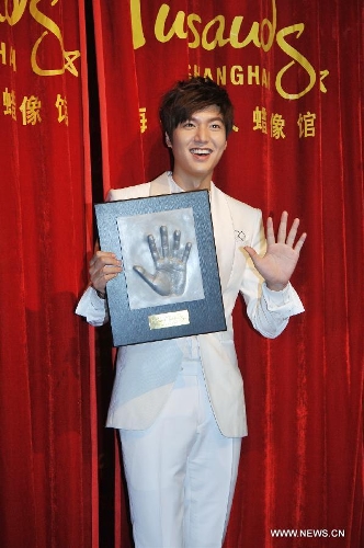South Korean actor Lee Min-ho shows his handprint as he attends a ceremony to unveil his wax figure at the Madame Tussauds in Shanghai, east China, April 19, 2013. (Xinhua) 