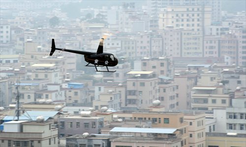 A helicopter hovers over a residential area as part of an anti-drug patrol in Huizhou, Guangdong Province on Tuesday. It was the first time helicopters were deployed to patrol the city for drug labs, often hidden in rented rooms, police said. Photo: IC