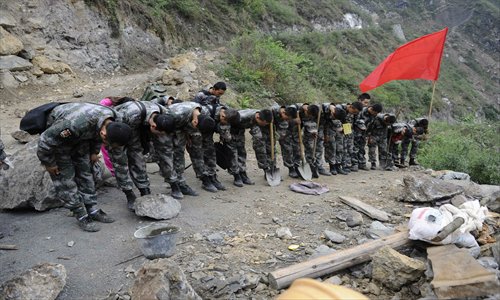 Soldiers mourn for the dead of the 7.0-magnitude earthquake that jolted Ya'an, Sichuan Province on Tuesday by bowing in front of a body on Tuesday. The death toll had risen to 193 as of Tuesday night. Photo: Li Hao/GT