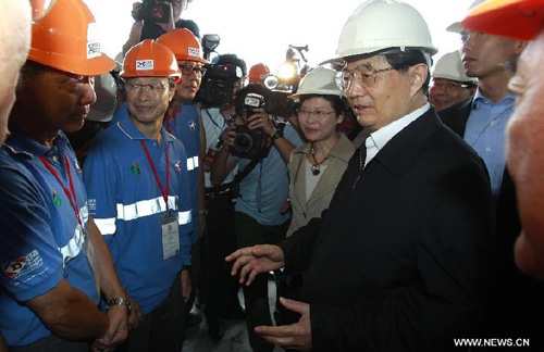 Chinese President Hu Jintao (R) talks with technicians and workers at the Kai Tak cruise terminal construction site in Hong Kong, south China, June 30, 2012. The cruise terminal project is part of a comprehensive Kai Tak development plan which is going in an area of 320 hectares near the Chinese mainland. Photo: Xinhua