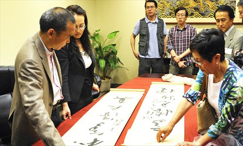 Guangyao and Zeng Jun, famous experts from the Forbidden City Palace Museum, discuss calligraphy at a Chinese school in Irvine, California. The experts were accompanied to the US by Xiong Changliang, vice president of the China Overseas Exchange Association. Photo: Mao Jianjun
