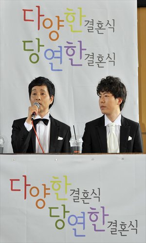 Kim (left) sits next to his partner at a press conference. Photo: IC
