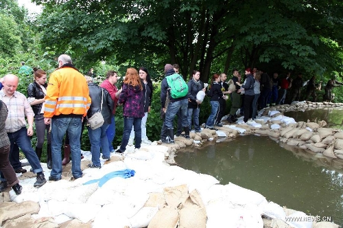 &nbsp;German Bundeswehr soldiers and local volunteers line up to pass on sandbags to beef up the dike at Gimritzer Dammin in Halle, eastern Germany, on June 4, 2013. The water level of Saale River across Halle City is expected to rise up to its historical record of 7.8 meters in 400 years, due to persistent heavy rains in south and east Germany. (Xinhua/Pan Xu)&nbsp; 