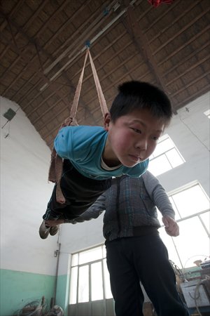 A boy trains with his teacher’s help. Photo: CFP