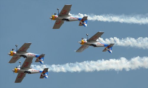 The Red Bull Aerobatics team display their skills during the opening of the Aero India 2013 air show at the Yelahanka air base in the southern Indian city of Bangalore Wednesday. The 9th Aero India show will be held from Wednesday t0 Sunday in Bangalore and is expected to show more than 50 civil and military aircraft from leading manufacturers around the globe. Photo: CFP