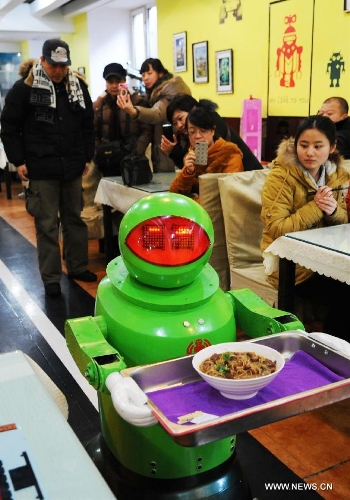 A robot serves dishes in a robot themed restaurant in Harbin, capital of northeast China's Heilongjiang Province, Jan. 18, 2013. Opened in June of 2012, the restaurant has gained fame by using a total of 20 robots to cook meals, deliver dishes and greet customers. (Xinhua/Wang Jianwei) 