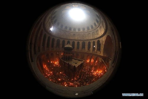Christian pilgrims hold candles in the Church of the Holy Sepulchre, traditionally believed to be the burial site of Jesus Christ, during the ceremony of the Holy Fire in Jerusalem's Old City, May 4, 2013. (Xinhua/Muammar Awad) 