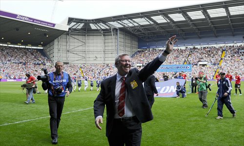 Manchester United's former manager Alex Ferguson (front) waves to fans before the start of the English Premier League match between West Bromwich Albion and Manchester United on Sunday. Photo: AFP