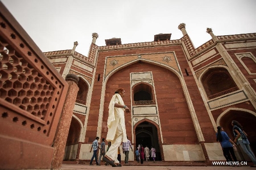 Tourists visit Humayun's Tomb in New Delhi, capital of India, May 12, 2013. Humayun's Tomb, located in east New Delhi, was built in 1569 to 1570 by Humayun's widow. As a precursor to the Taj Mahal, it stands on a platform of 12,000 square meters and reaches a height of 47 meters. The earliest example of the Persian influence in Indian architecture, the tomb itself is in the center of a large garden, surrounded by 12 hectares of gardens with pools joined by channels. The tomb brought Persian style to Delhi, but the two-tone combination of red sandstone and white marble is local, which shows the merging of different cultures. Humayun's Tomb was inscribed on the World Heritage List by the United Nations Educational, Scientific and Cultural Organization in 1993. (Xinhua/Zheng Huansong) 
