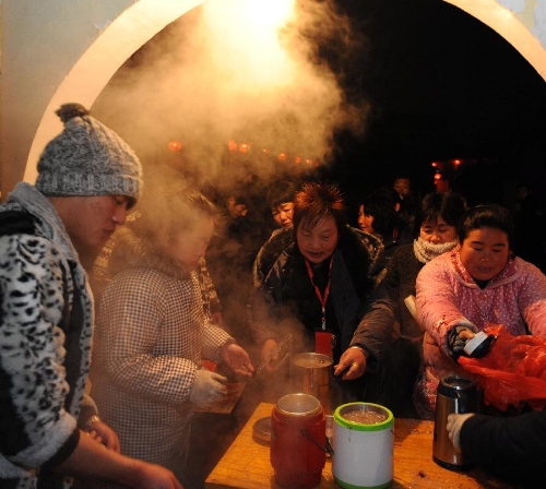 Citizens queue to get free porridge at Baiyi Buddhist Convent in Bozhou, east China's Anhui Province, Jan. 19, 2013. The Baiyi Buddhist Convent distributed Laba porridge for free on Jan. 19, the eighth day of the 12th lunar month or the day of Laba Festival. The Laba Festival is regarded as a prelude to the Spring Festival, or Chinese Lunar New Year, the most important occasion of family reunion, which falls on Feb. 10 of this year. Drinking Laba porridge on the day of Laba is a traditional custom in China. (Xinhua/Zhang Yanlin) 