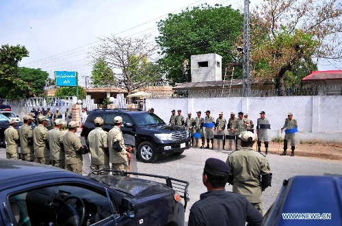 Paramilitary troops stand guard as a vehicle carrying Pakistan's former president Pervez Musharraf leaves an anti-terrorism court in Rawalpindi, adjacent city of Islamabad, capital of Pakistan, on April 23, 2013. The Pakistani anti-terrorism court, conducting the trial of suspects charged with involvement in the 2007 assassination of former Prime Minister Benazir Bhutto on Tuesday ordered that former President Pervez Musharraf would be included in the investigation process. (Xinhua/Ahmad Kamal)