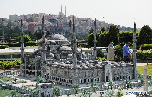 &nbsp;A visitor takes photos in front of the miniature of the Blue Mosque in the Miniature park in Istanbul, Turkey, on May 11, 2013. The Miniaturk park is the first miniature park in Istanbul and has welcomed 6.5 million visitors over the past 10 years. (Xinhua/Lu Zhe) 