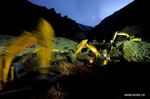 Rescue workers conduct search and rescue work at the site where a large-scale landslide hit a mining area in Maizhokunggar County of Lhasa, southwest China's Tibet Autonomous Region, March 30, 2013. Rescuers have found bodies and are still searching for survivors more than 37 hours after a massive landslide buried 83 miners at the polymetal mine in Tibet. (Xinhua/Purbu Zhaxi)