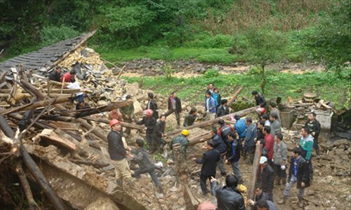 Rescuers search at the landslide site in the village of Zhenhe, located in Yiliang County of Zhaotong City in southwest China's Yunnan Province, October. 4, 2012. Nineteen people, including 18 students, were buried in a landslide here on Thursday. Eighteen people have been confirmed dead and one people remain missing. Photo: Xinhua