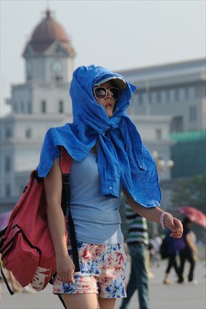 A tourist tries to gain a measure of protection from the heat near Tiananmen Square in Beijing on Monday. Photo: CFP