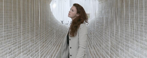 A working staff watches the monumental rice paper boat by renowned Chinese artist Zhu Jinshi during the media preview of the Art 13 London new modern and contemporary art fair at Olympia Grand Hall in London, Feb. 28, 2013. The 12-metre-long installation made of 8,000 sheets of rice paper and presented by Pearl lam Galleries was built by 20 people over three days and brought to London from Shanghai. (Xinhua/Yin Gang) 