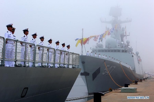Officers and soldiers of Chinese navy take part in a ceremony for the departure of a fleet in the port of Qingdao, east China's Shandong Province, July 1, 2013. A Chinese fleet consisting of seven naval vessels departed from east China's harbor city of Qingdao on Monday to participate in Sino-Russian joint naval drills scheduled for July 5 to 12. The eight-day maneuvers will focus on joint maritime air defense, joint escorts and marine search and rescue operations. (Xinhua/Zha Chunming)