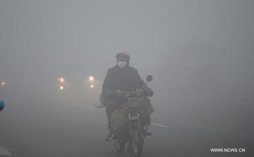 A citizen rides amid dense fog in Nanchang City, capital of east China's Jiangxi Province, Jan. 12, 2013. A fog hit many parts of Jiangxi on Saturday. (Xinhua/Zhou Ke)&nbsp; 