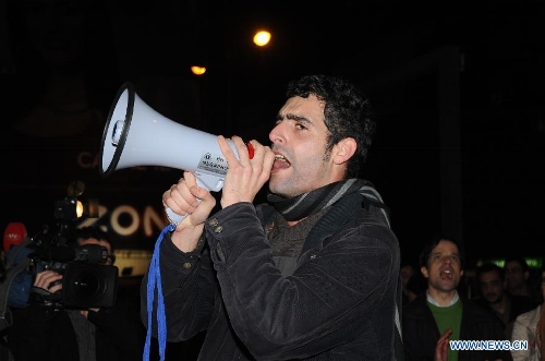 A protestor uses a loudspeaker to shout slogans in front of the Internatioanl Monetary Fund (IMF) Office in Lisbon, Portugal, on Jan, 30, 2013. Hundreds of Portuguese gathered in front of the Internatioanl Monetary Fund (IMF) Office in capital Lisbon, protesting against IMF's demand of more spending cuts by the Portuguese government and its drastic austerity policy. (Xinhua/Zhang Liyun)